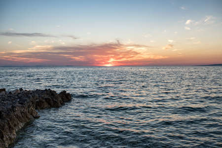 Beautiful sunset over the sea with rocky shoreの写真素材