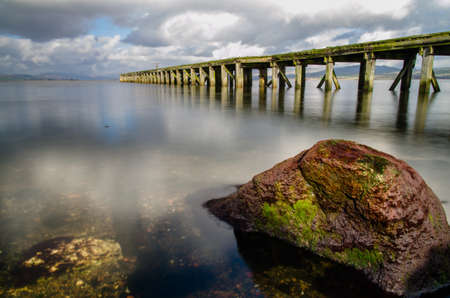 Photo of pier and red stone in Scotland