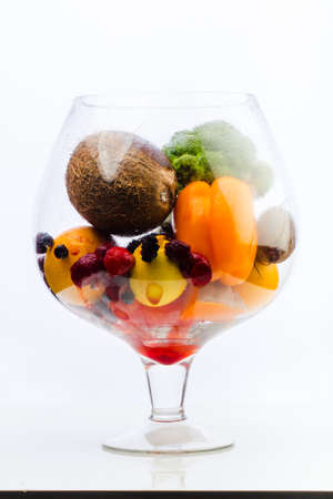 aquarium with healthy food, fruits, vegetables and berries strawberries, strawberry, raspberry, coconut, broccoli, pepper, orange, lemon juice juicy on a white backgroundの写真素材