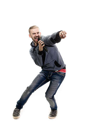 studio portrait of a singer isolated on white backgroun, a nice young man with blond hair singing a drive, holding a microphone in his hand, rockerの写真素材
