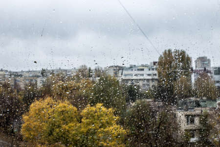 Rain drops on the window in the big city.の写真素材