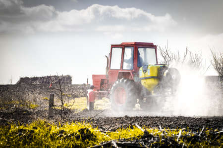 red tractor in a field waters garden, creative backgroundの写真素材