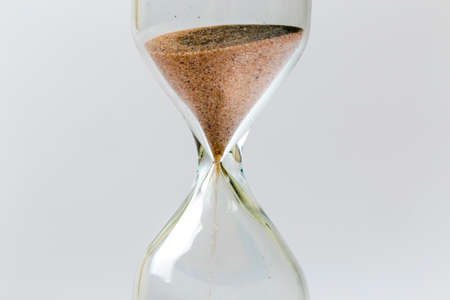 Sand flowing through an hourglass concept for time running out, backgroundの写真素材