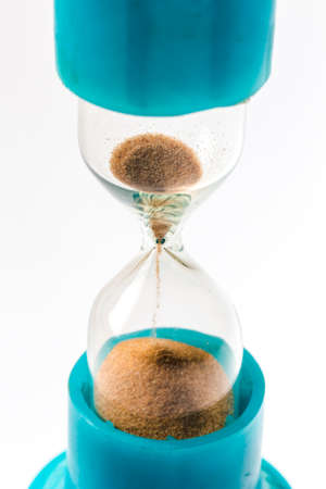 Sand flowing through an hourglass concept for time running out, backgroundの写真素材