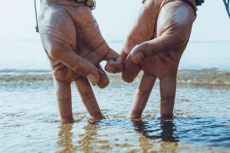 conceptual picture - two hands in the form of couple, walking on the beach at sunrise. personalized hands standing on two fingers symbolizing the people.の写真素材