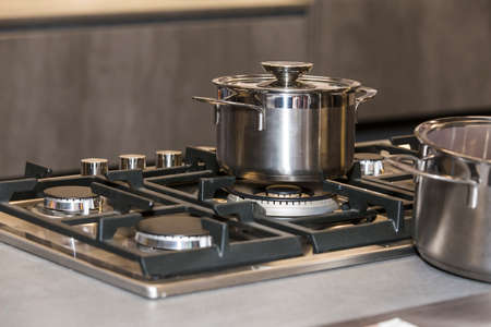 photo of shiny metal pan on a gas stove, shallow DOF focus on panの写真素材