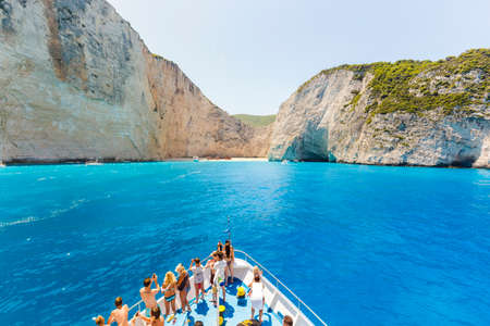 10 July 2016 Amazing landscape of Navagio beach with shipwreck on Zakynthos island, cruise ship with people on deck, approaching to the bay. Greece.のeditorial素材