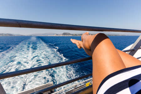 sexy young woman legs relaxing on cruise ship travel holiday.の写真素材