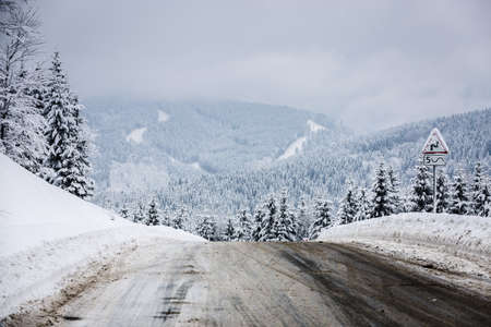 Partially purified snow-covered road in the mountains, shallow DOFの写真素材