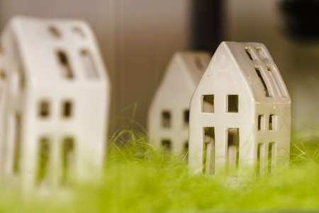 A minimalistic model of a white house carved and sliced from plastic, on a green grassの写真素材