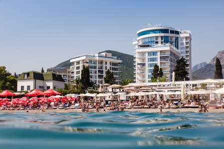 24 august 2017, people are relaxing on the beach, Tre Canne hotel on the background, view from the sea Budva, Montenegro.のeditorial素材