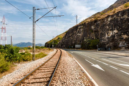 railway on the background of the mountains next to the highwayの写真素材