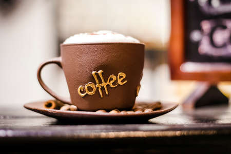 brown coffee cup with "coffee' inscription, with foam shallow DOF.の写真素材