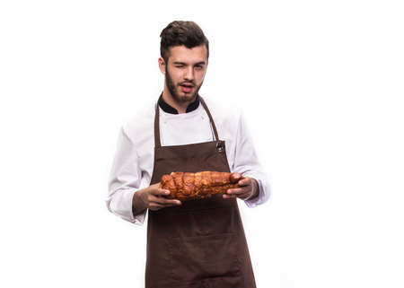 the cook holds a ham in his hands and winks at the cameraの写真素材
