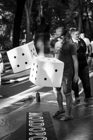 6 june 2015 an unidentified guy plays in a monopoly on the street with big cubes,black and white photo, Chisinau, Moldovaのeditorial素材