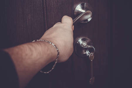 a man's hand, holds his hand on the doorknobの写真素材