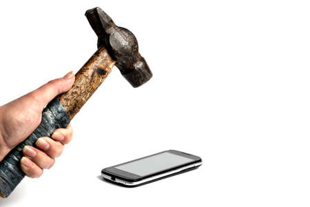 black phone on a white background, hammer in a female hand is getting ready impact smartphoneの写真素材