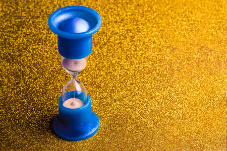 hourglass on gold glitter, background image, concept time of money or golden timeの写真素材