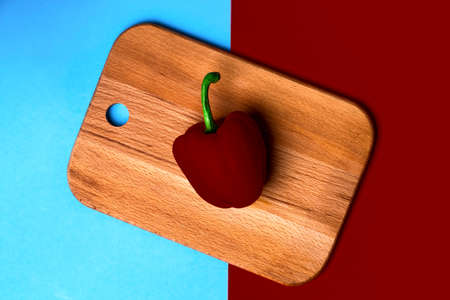 burgundy fresh paprika on a wooden plank for kitchen, on a bright colorful background, flat lay imageの写真素材
