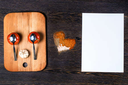 cartoon muzzle on a wooden background next to the heart of spices and a white sheet to write your version, the concept of love eating a choiceの写真素材