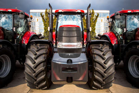 new, beautiful, red with black wheels tractor, close-up, background image