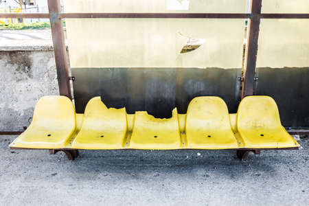 damaged yellow chairs at the bus stop, close-up, background imageの写真素材