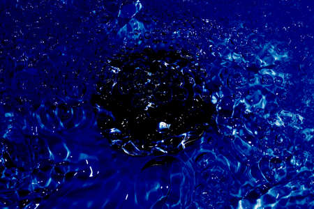 washbasin with a drain in the center of the photo with flowing blue water