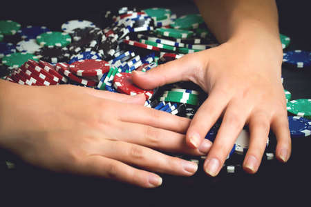 victorious rejoicing to all chips after poker game, greedy woman taking all money, toned imageの写真素材