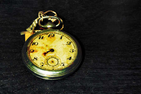 old pocket clock on a wooden background, image with space for textの写真素材