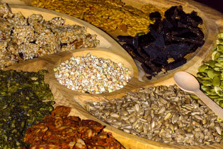 a plateau of oriental sunflower seeds and nuts in a wooden tray background image