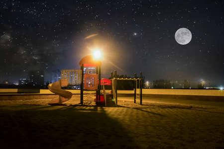 an empty  playground  against the background of the starry sky and the full moon, the concept of children's dreamsの写真素材