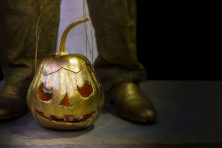 golden pumpkin with ropes standing on the floor, background image with space for textの写真素材