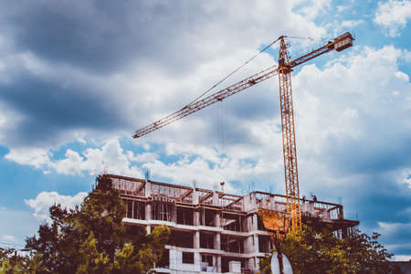 construction of a new residential complex with a yellow crane, toned background imageの写真素材