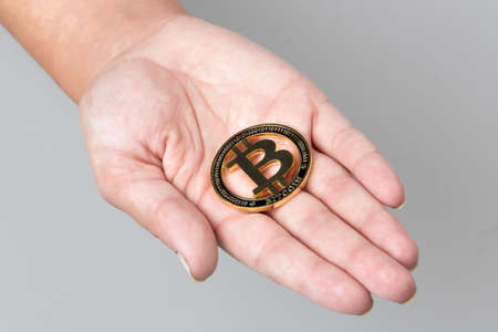 golden bitcoins on the hand on a light backgroundの写真素材