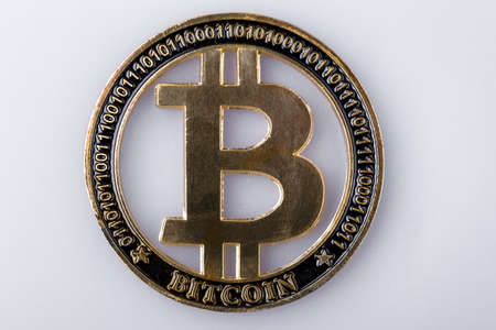 golden bitcoin on a light surface, close-up background image