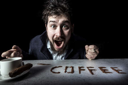 portrait of cheerfully rejoicing coffee man on black background, concept coffee is a drugの写真素材