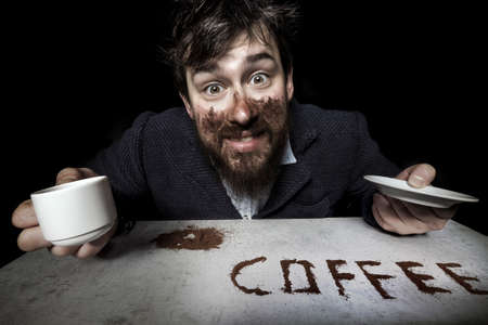 bearded man smeared with coffee, looking madly at the camera, the concept of coffee is a drugの写真素材