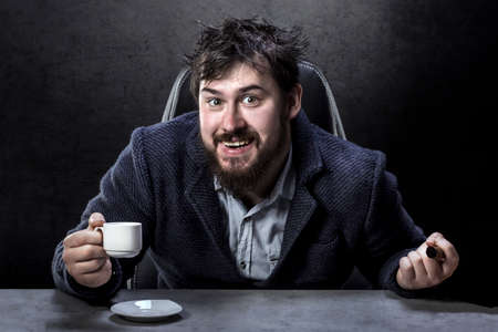 portrait of a crazy bearded man in the director's chair with a cigar and coffee in hand