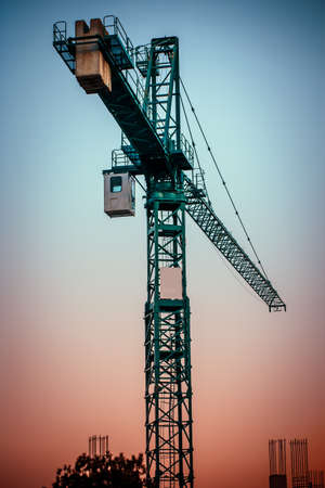 green construction crane at sunset, vertical imageの写真素材