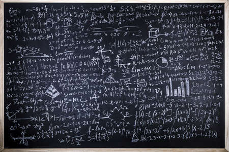 Blackboard inscribed with scientific formulas and calculations in physics and mathematics,...