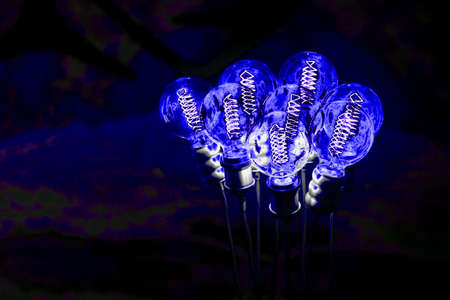 blue burning light bulbs against a dark wall. Shallow DOF
