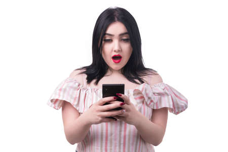 plus size model looks into the phone with shocked emotion, isolated on white backgroundの写真素材