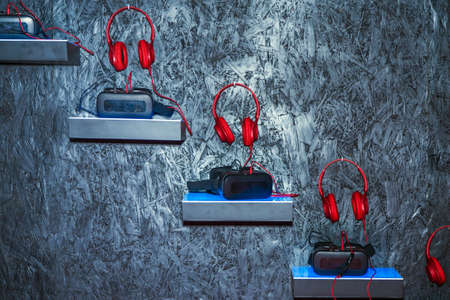 red headphones near to glasses for virtual reality on the background of a wooden gray wallの写真素材