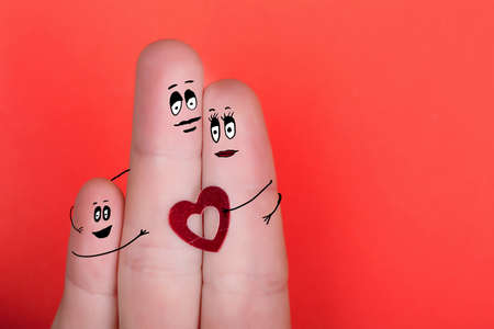 happy family of fingers with painted faces on red backgroundの写真素材