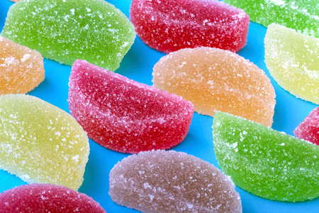 colored fruit jelly with sugar crystals on a blue backgroundの写真素材