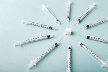 insulin syringes around a sugar cube, ambulance concept for diabetesの写真素材