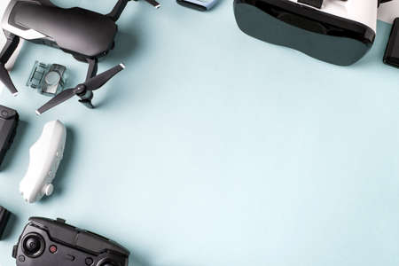 virtual reality glasses (VR) and a drone near to their accessories on a blue background with space for textの写真素材