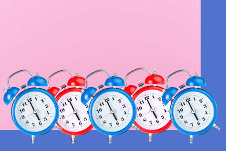 red and blue alarm clocks on a colorful backgroundの写真素材