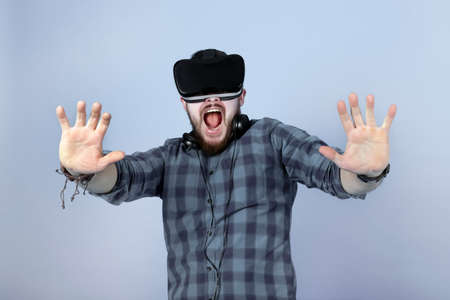 scared man with glasses of virtual reality, fear emotion, image on blue background
