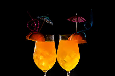 two delicious orange cocktails on a dark background, concept refreshing drink during the hot seasonの写真素材